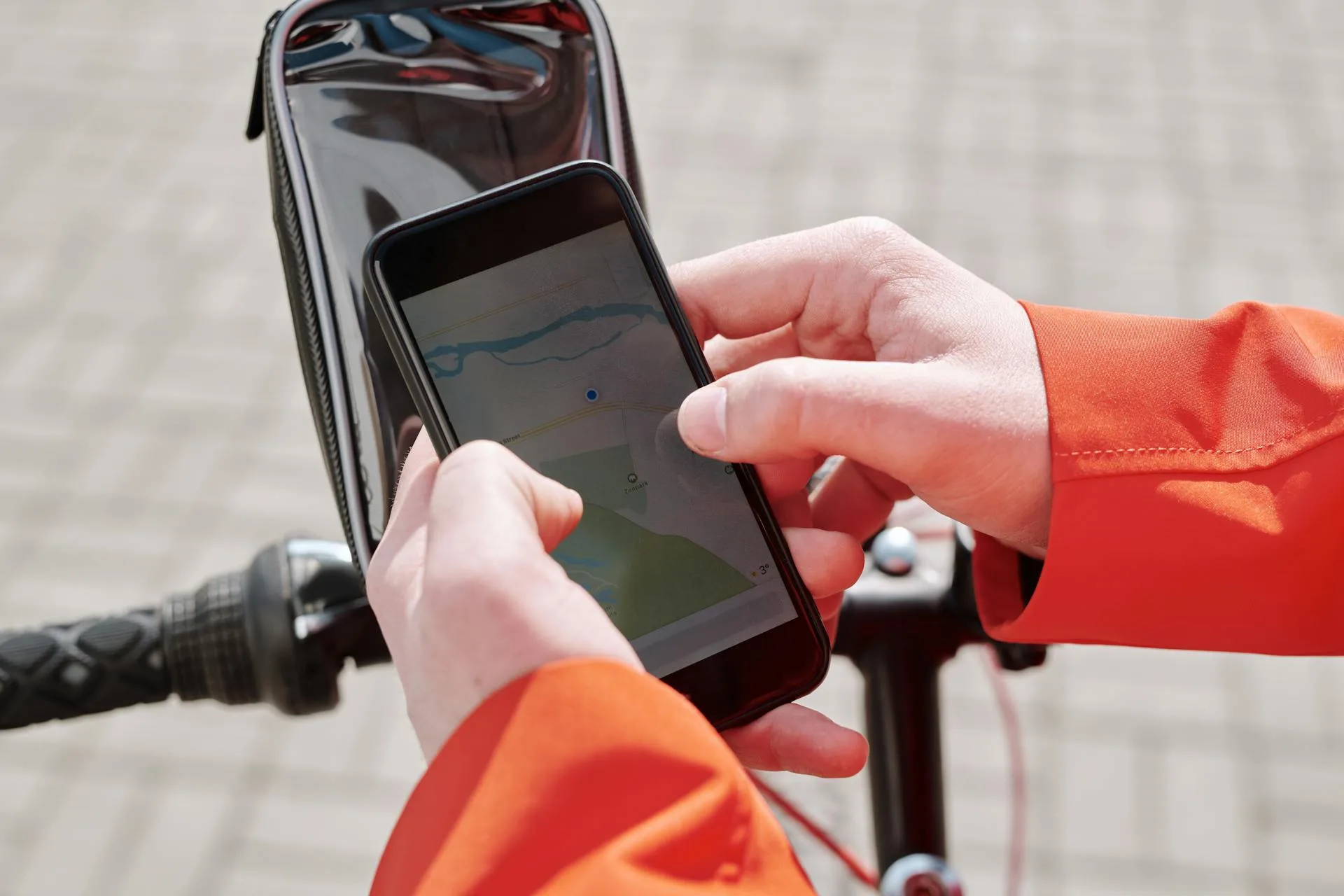 Close-up of cyclist using GPS navigation app on smartphone bike mount