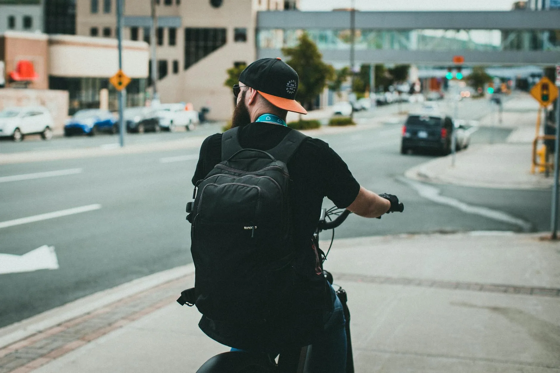 Cyclist wearing backpack while riding bike on urban street