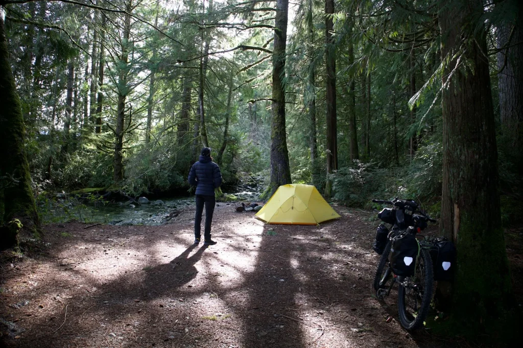 Bicycle parked next to tent in nature during bikepacking trip
