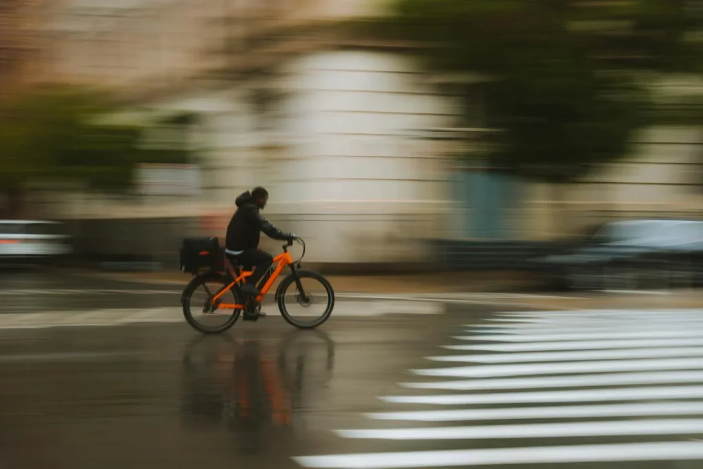 Cyclist riding through wet city streets demonstrating all-season e-bike tyre grip