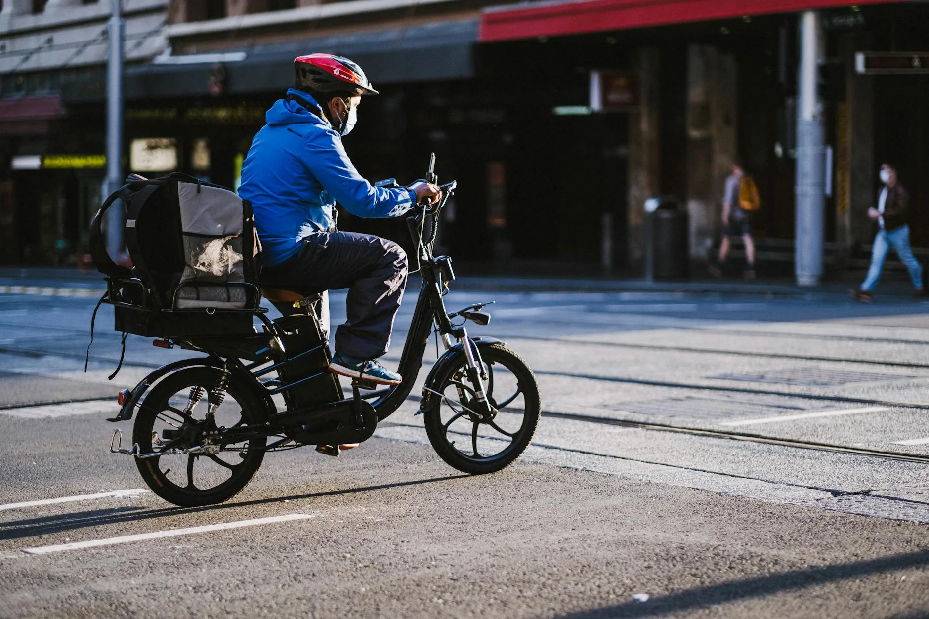 Person riding an electric bike through a city street on a commute