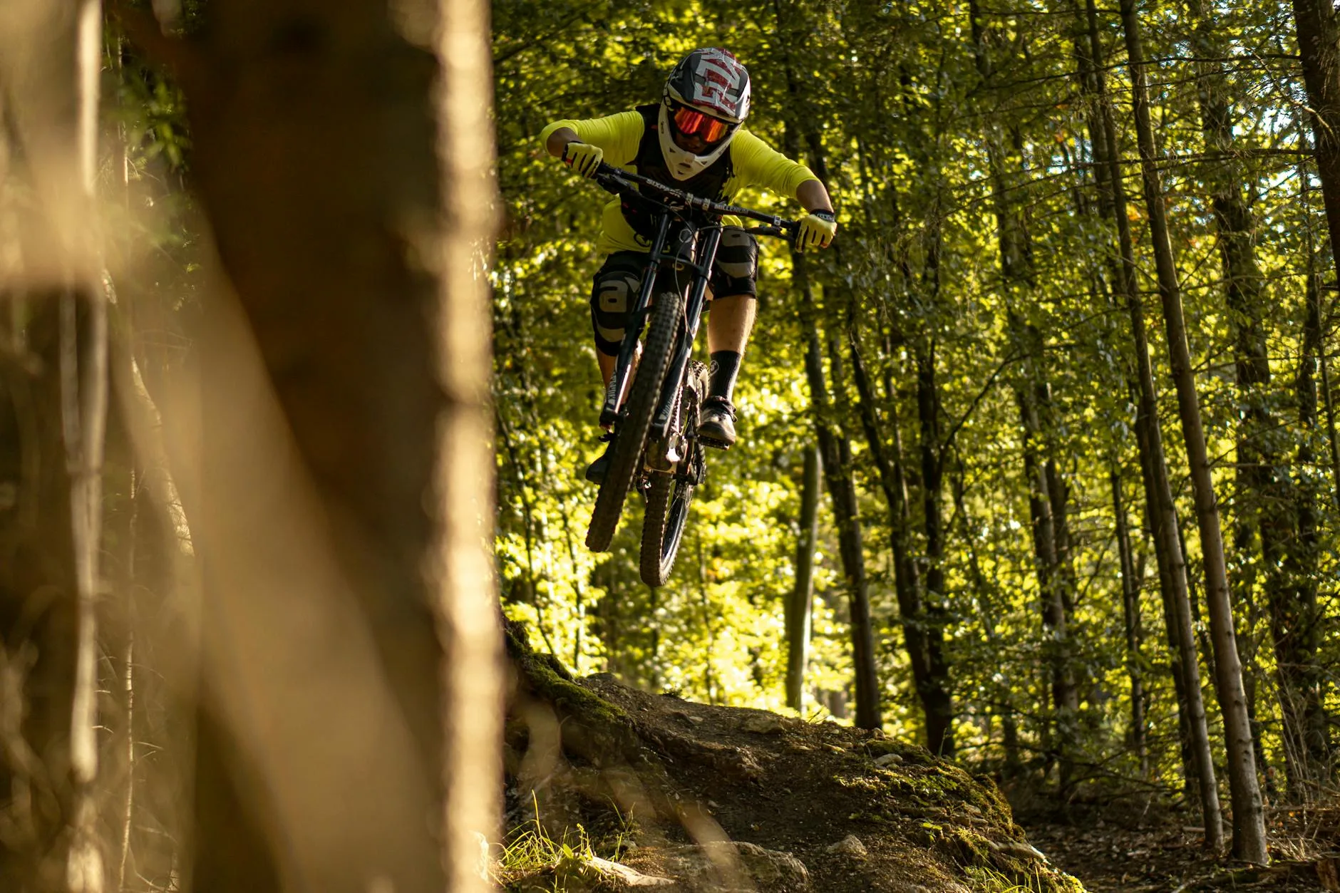 Mountain biker catching air on a forest trail descent