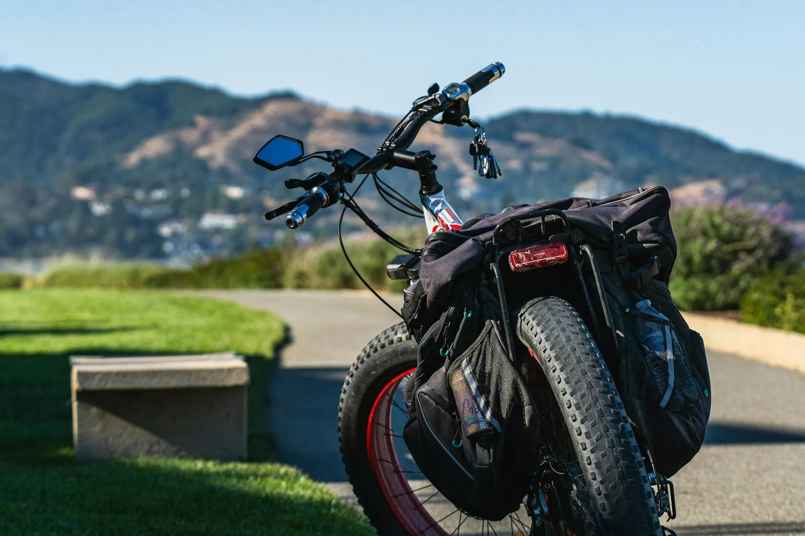 Fat-tyre e-bike with hub motor and loaded panniers on a scenic path
