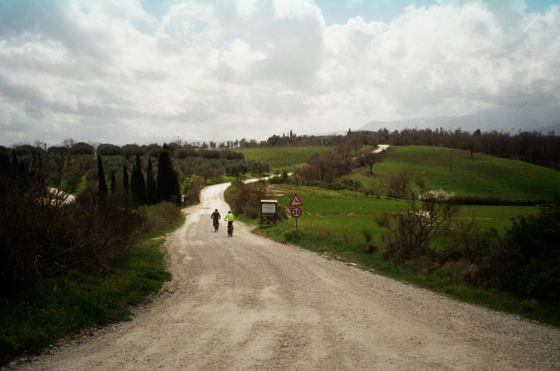 Cyclist riding along a country lane through green hills