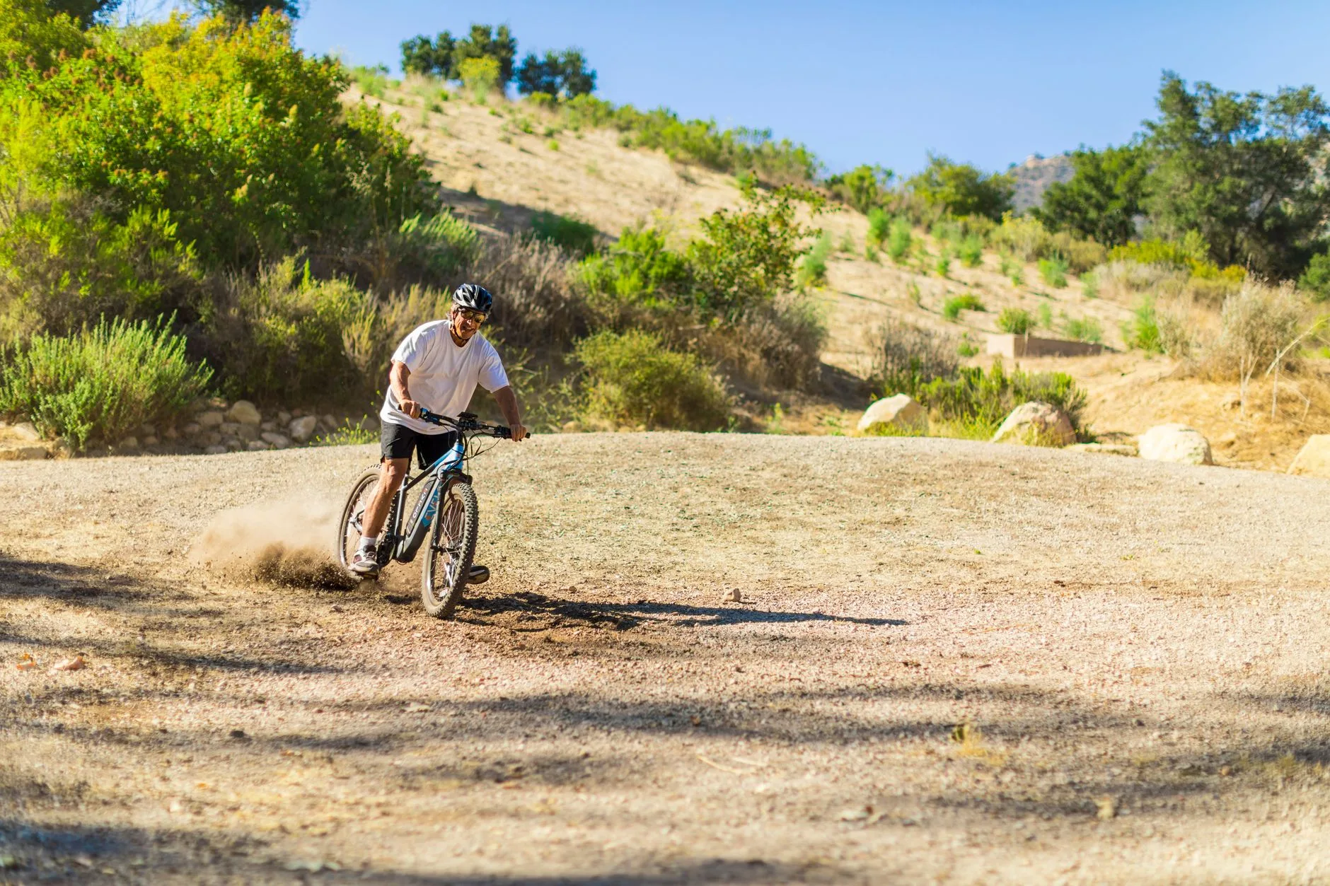 E-bike rider on a road where hills and weather affect real-world range
