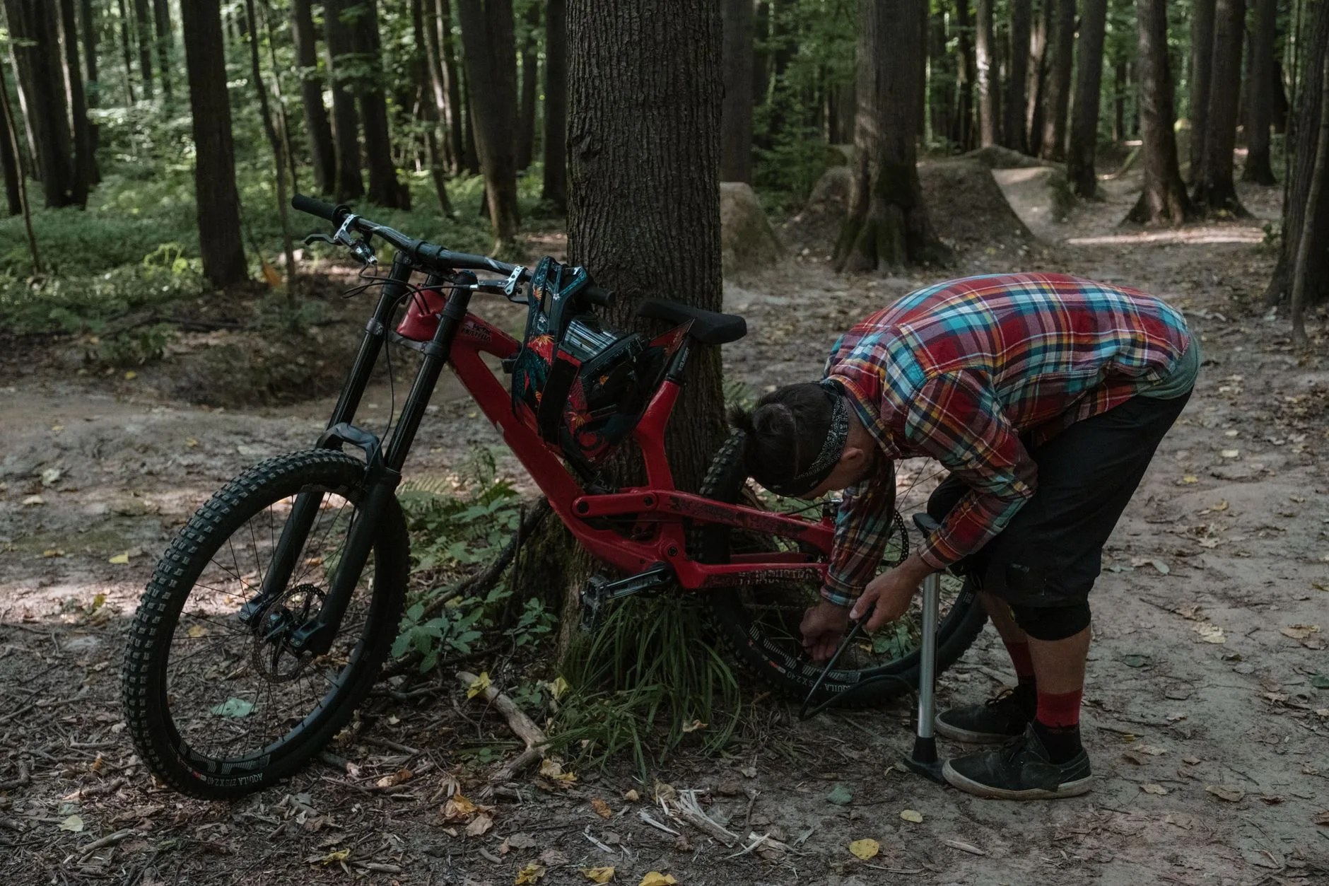 Rider checking the rear wheel and suspension area on an E-MTB