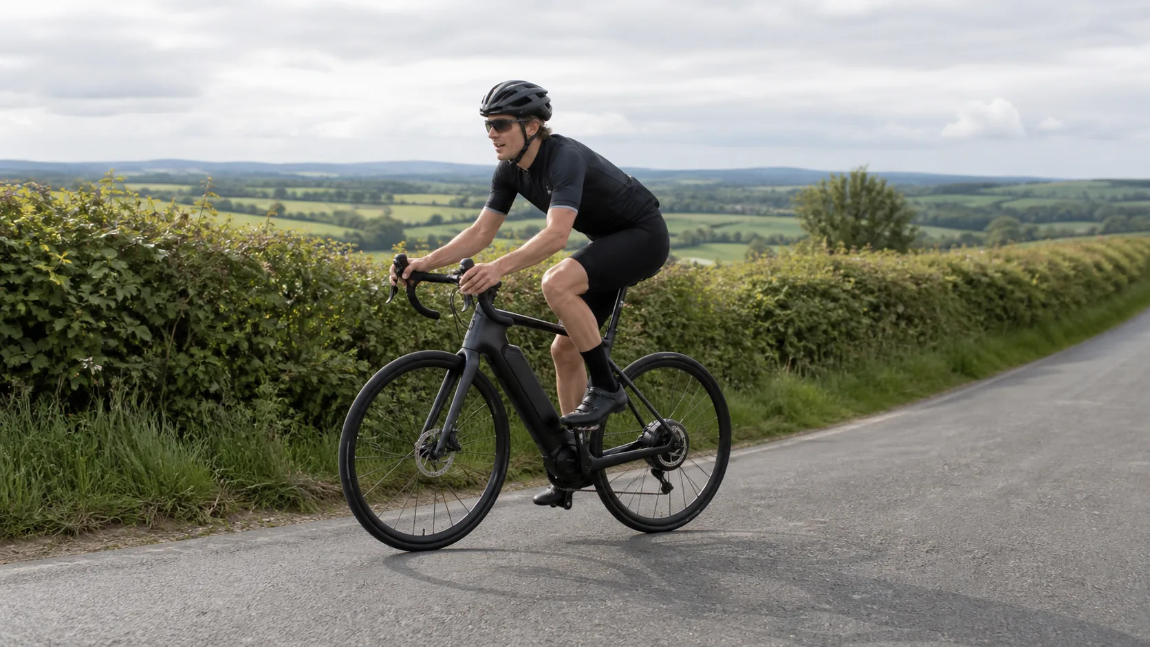 Electric road bike rider climbing a UK country lane